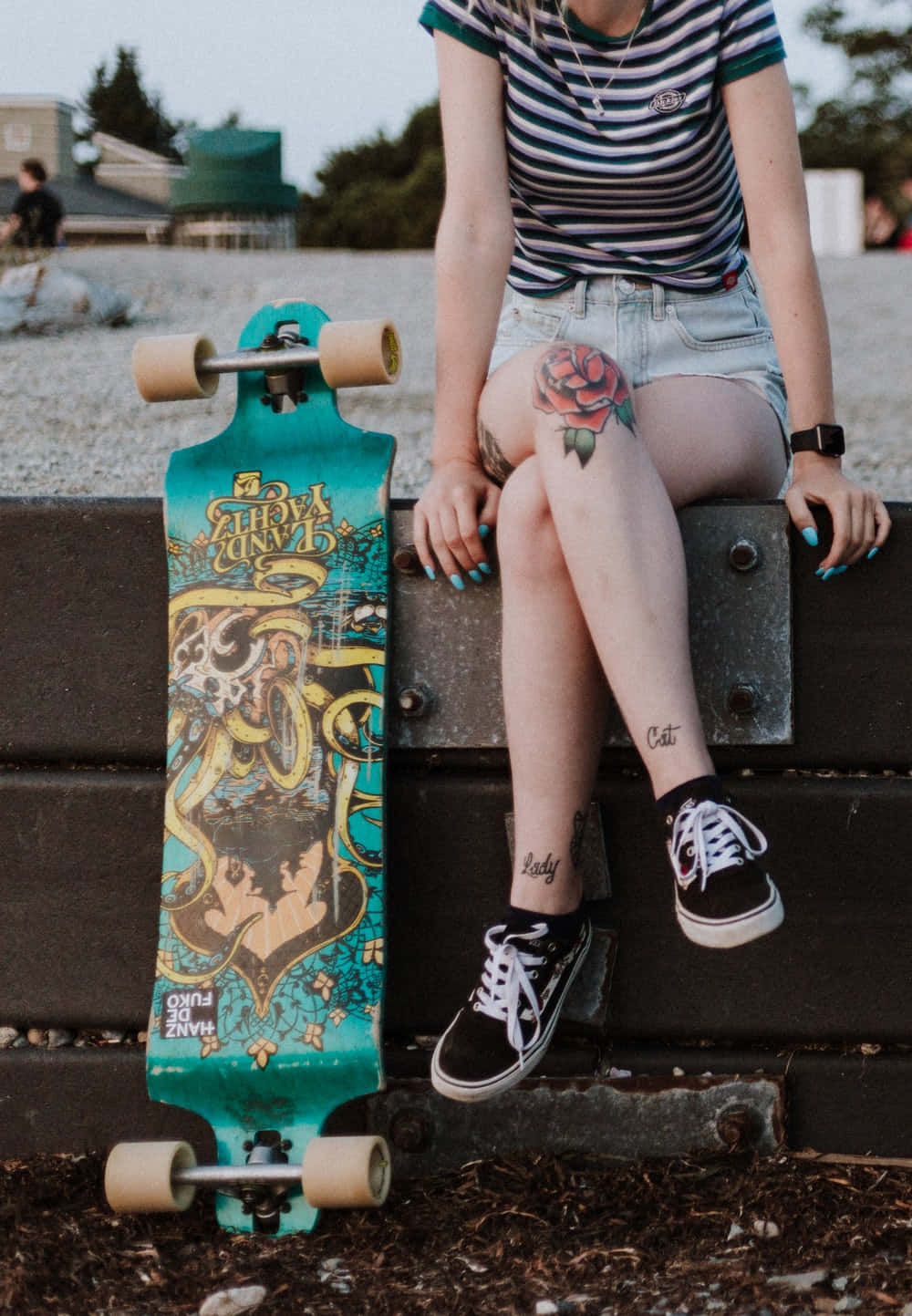 A Girl Sitting On A Bench With A Skateboard Wallpaper
