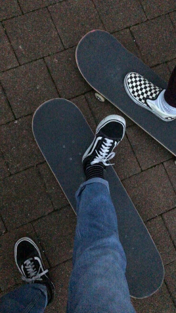 Two Skateboards On A Brick Walkway Wallpaper