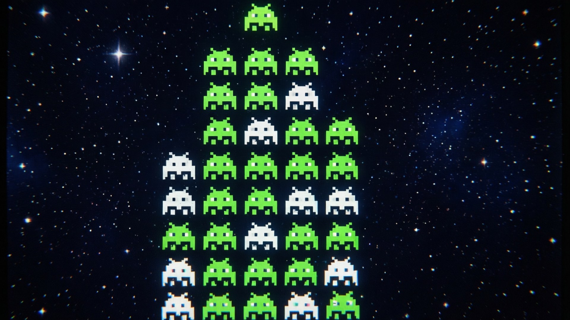 Klassiskt arkadrutnät av Space Invaders som sänker sig mot en stjärnklar bakgrund.