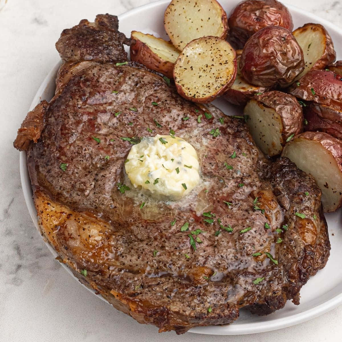 A Plate With A Steak, Potatoes And Butter