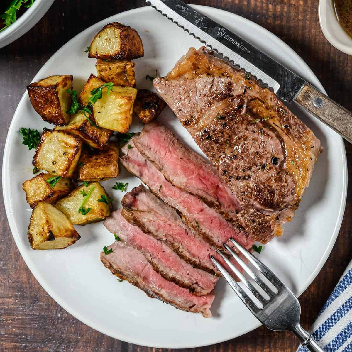 A Plate With Steak, Potatoes And A Fork
