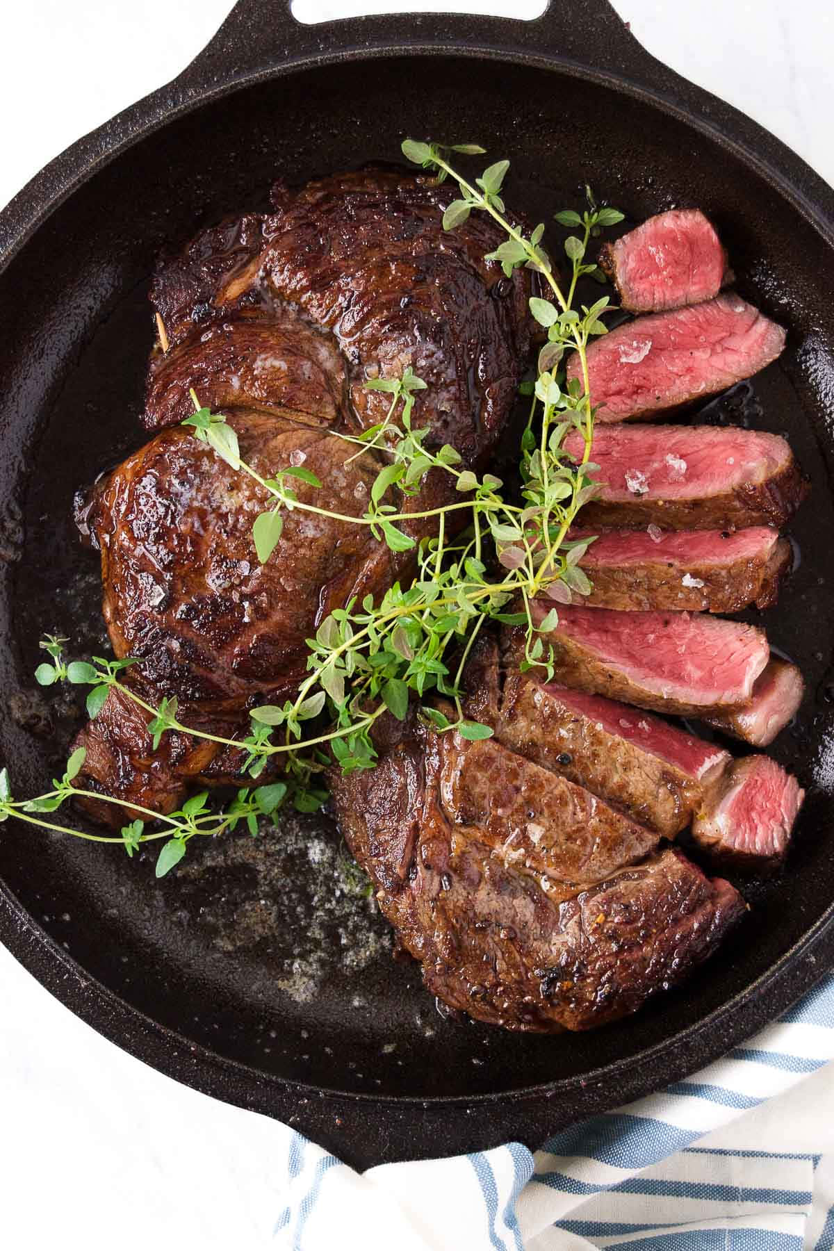 A Steak Is Being Cooked In A Cast Iron Skillet