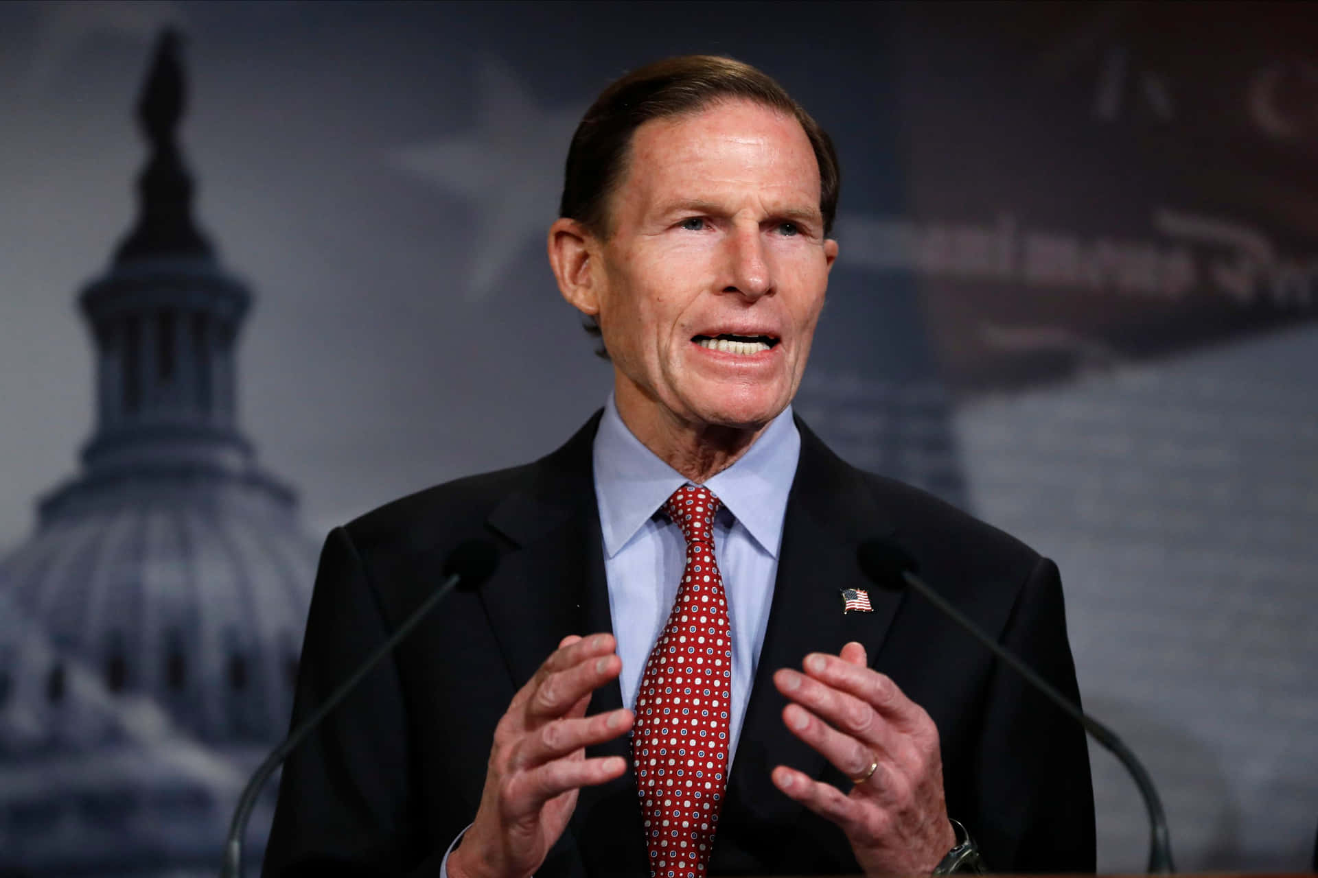 Richard Blumenthal With Gray Backdrop Of American Imagery Wallpaper