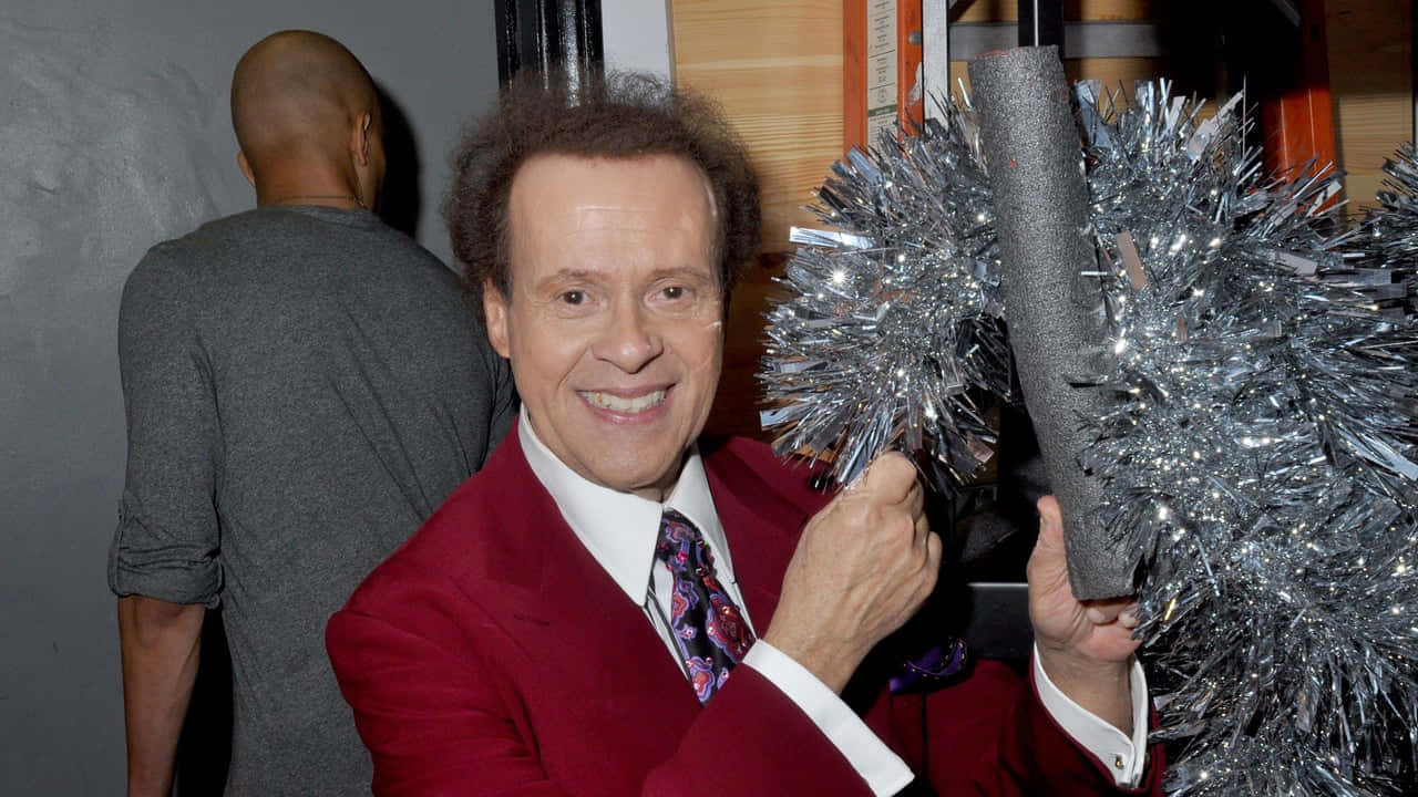 Richard_ Simmons_ Cheerful_ Pose_ With_ Pom Poms Wallpaper