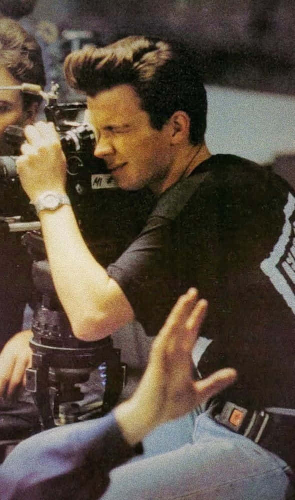 A Man Is Holding A Camera While Another Man Is Holding A Camera