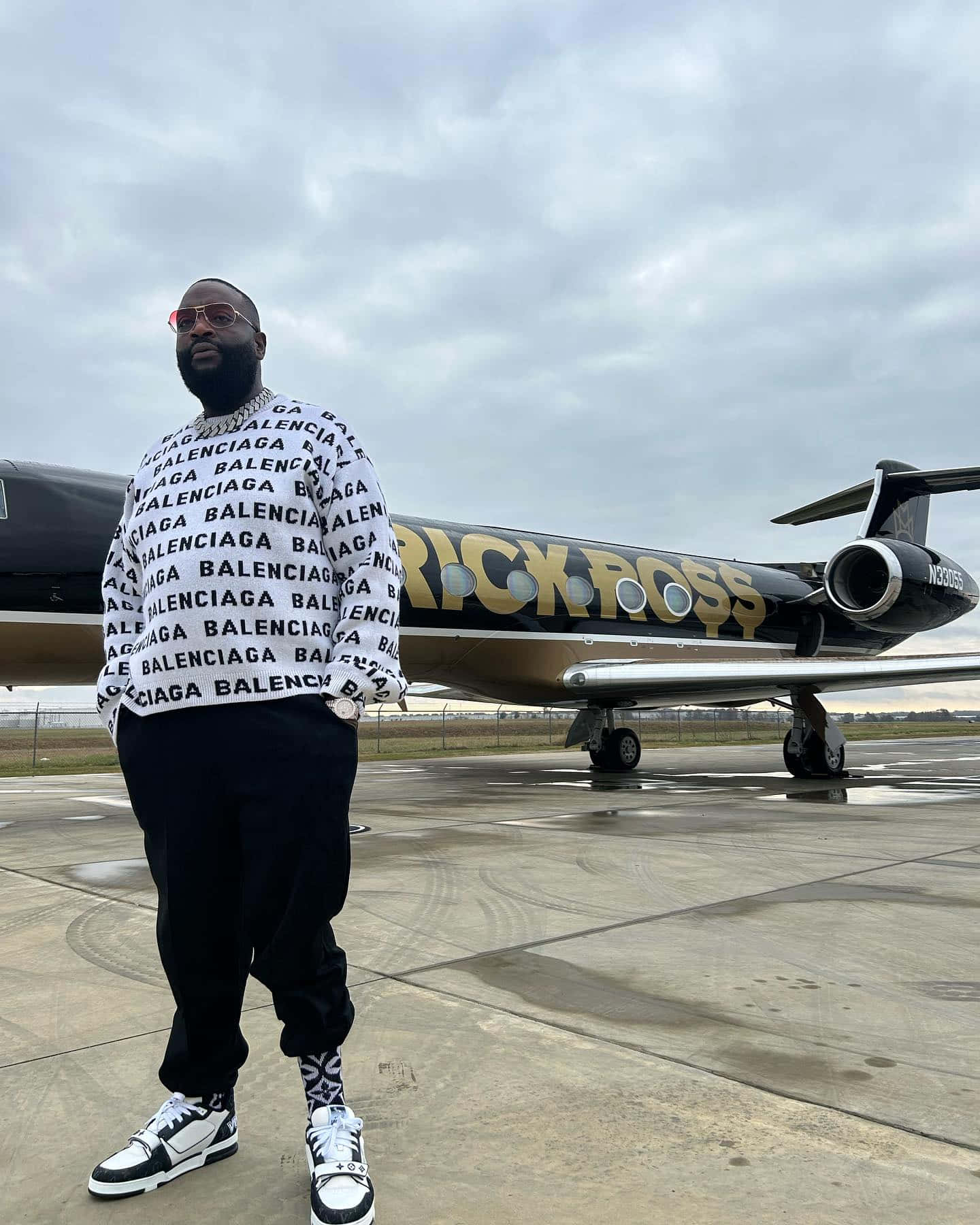 Rick Ross Standing Before Private Jet Wallpaper