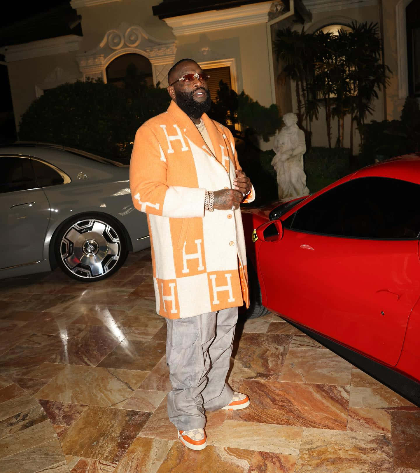 Rick Ross Stylish Outfit Luxury Cars Background Wallpaper