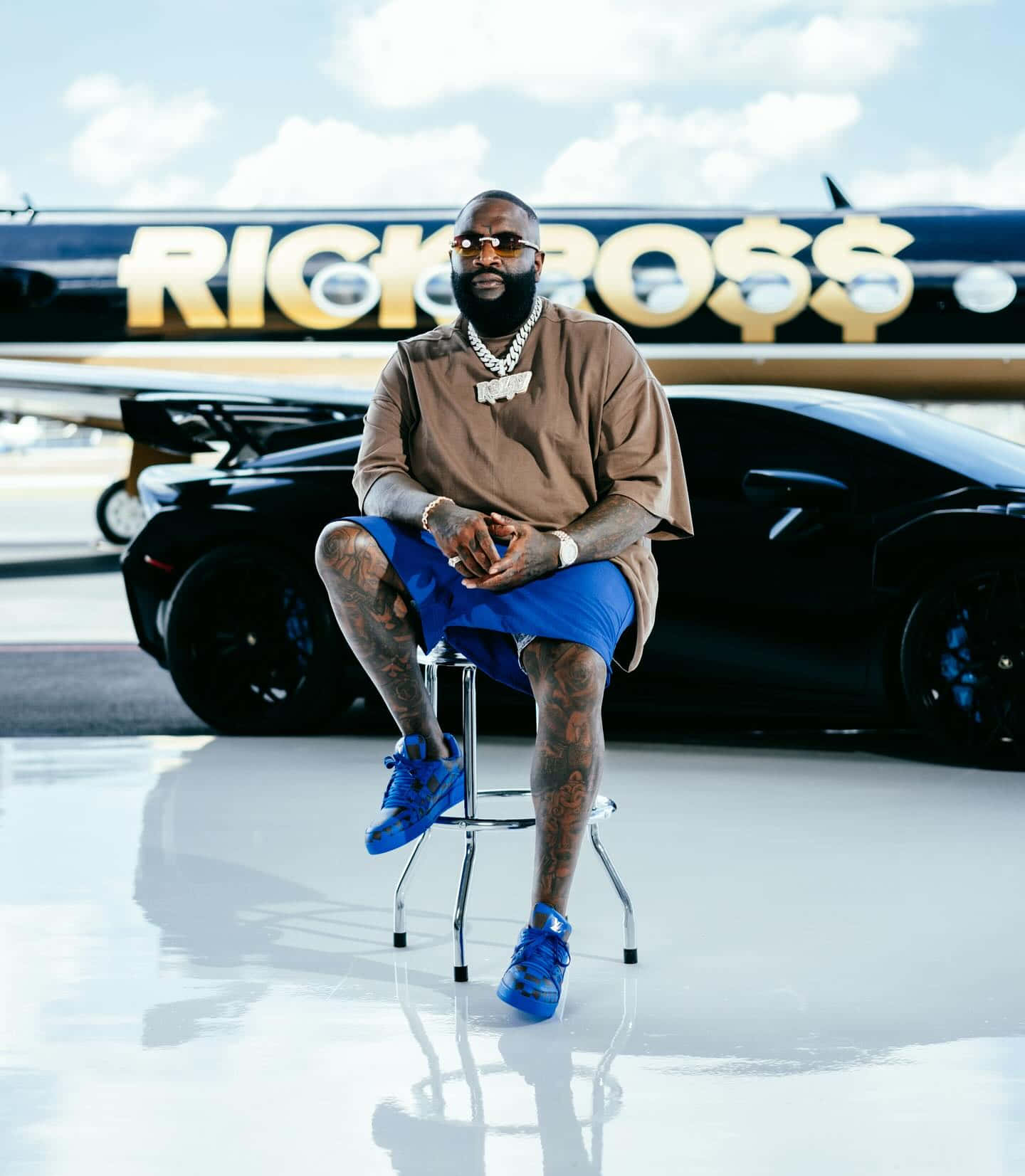 Rick Ross Stylish Pose With Private Jet And Car Wallpaper