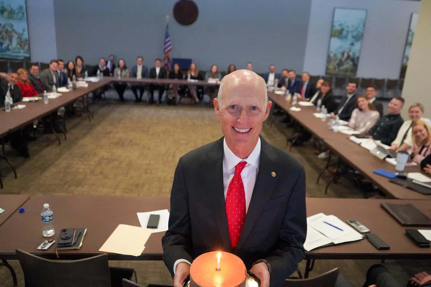 L'exgovernatore Della Florida Rick Scott, Mentre Tiene Una Torta Durante Una Festa. Sfondo