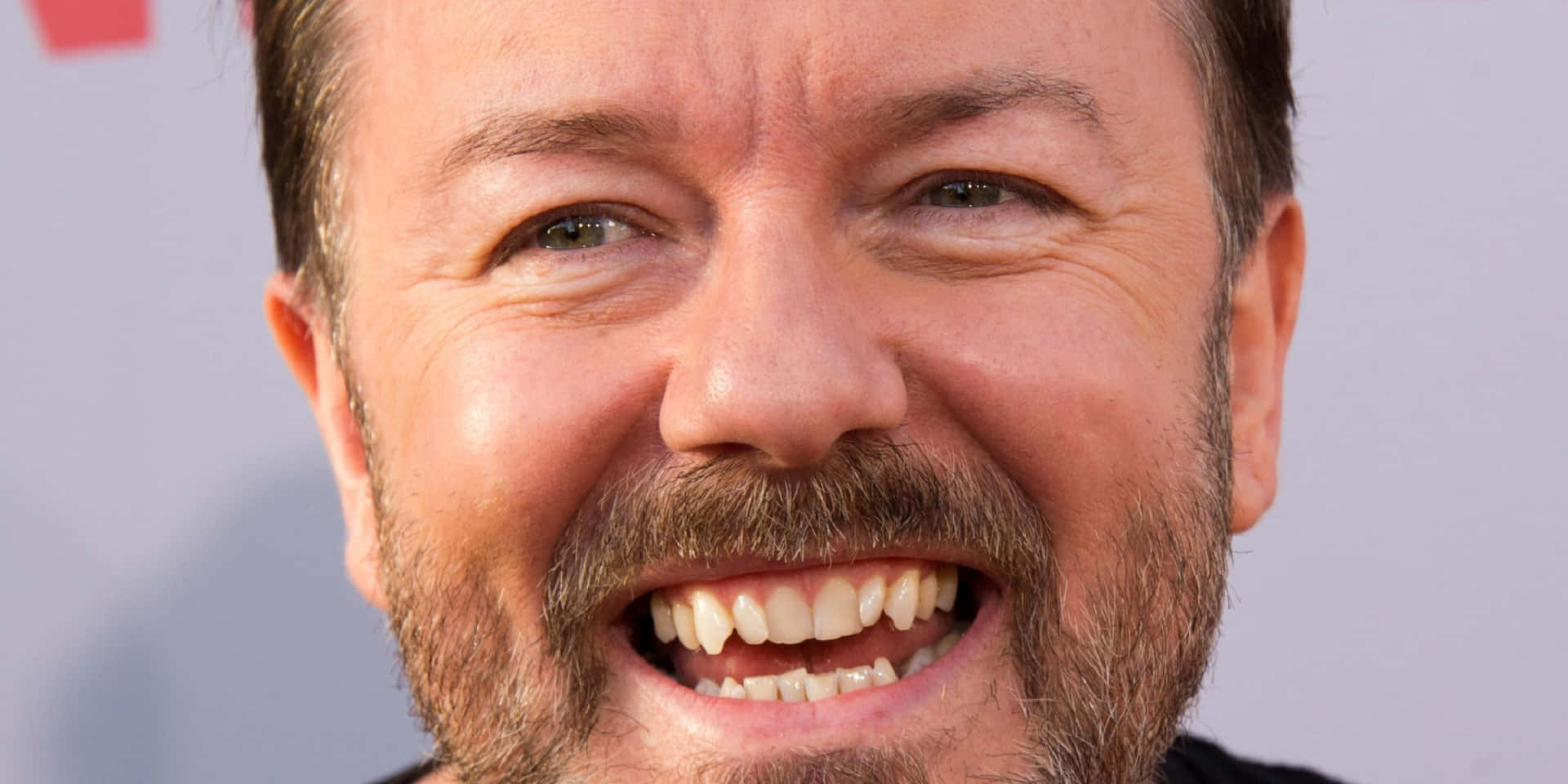 Rickygervais Se Pone Una Sonrisa. Fondo de pantalla