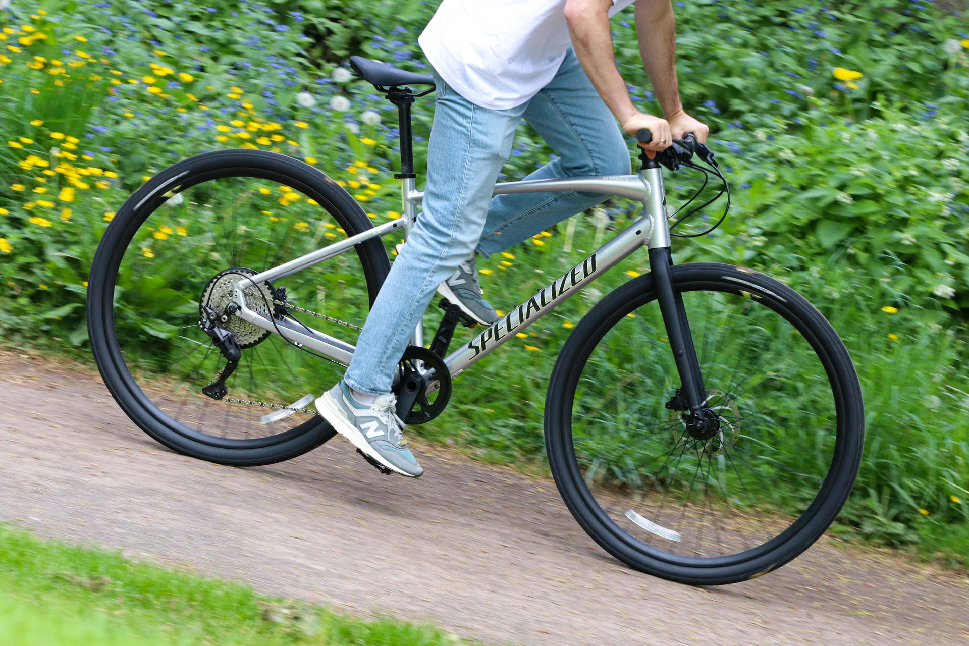 Guidareuna Bicicletta Specialized In Jeans Sfondo