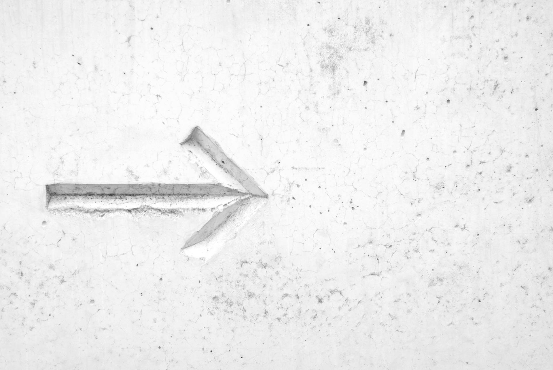 Make your next step with this Right Arrow Sign on a White Wall Wallpaper