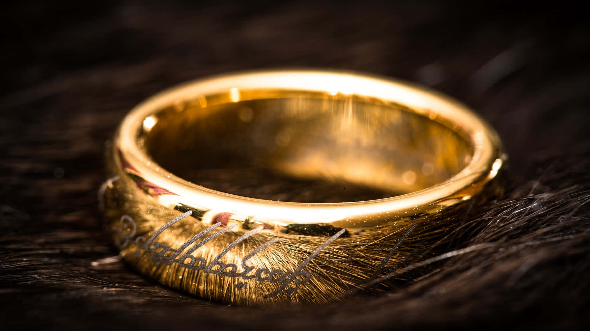 A Gold Ring With The Lord Of The Rings Written On It