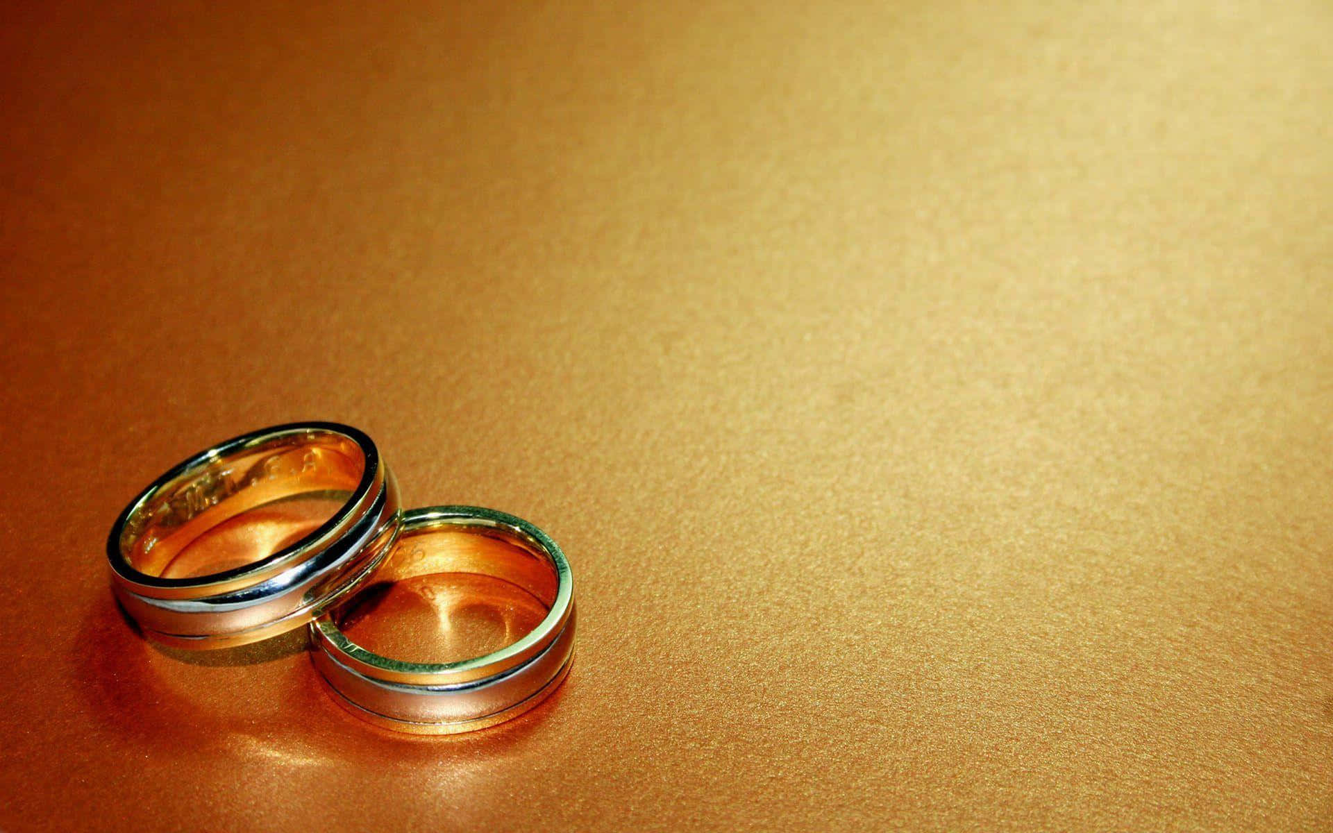 Two Wedding Rings On A Gold Surface