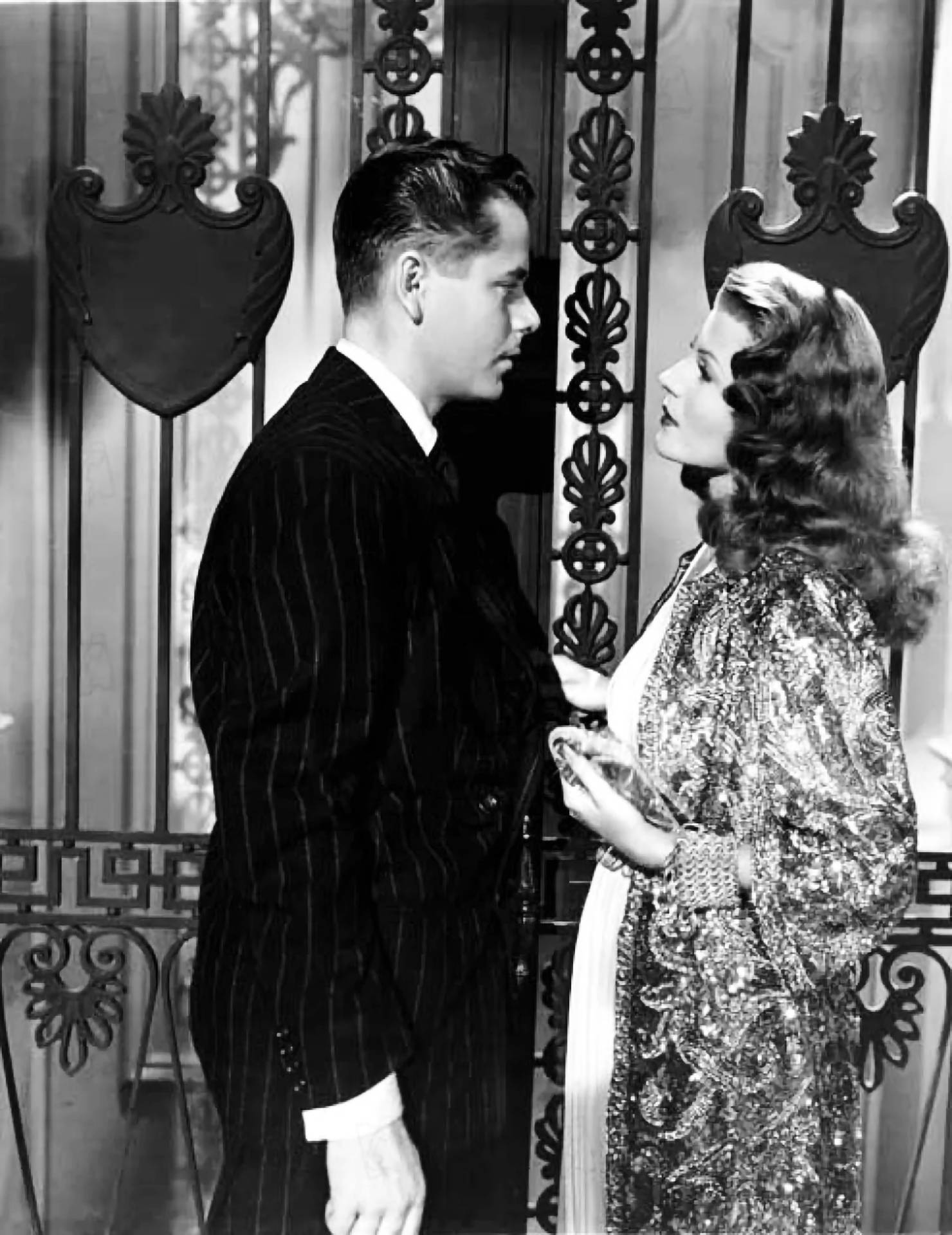 Rita Hayworth og Glenn Ford kigger ud fra et vintage filmplakat. Wallpaper