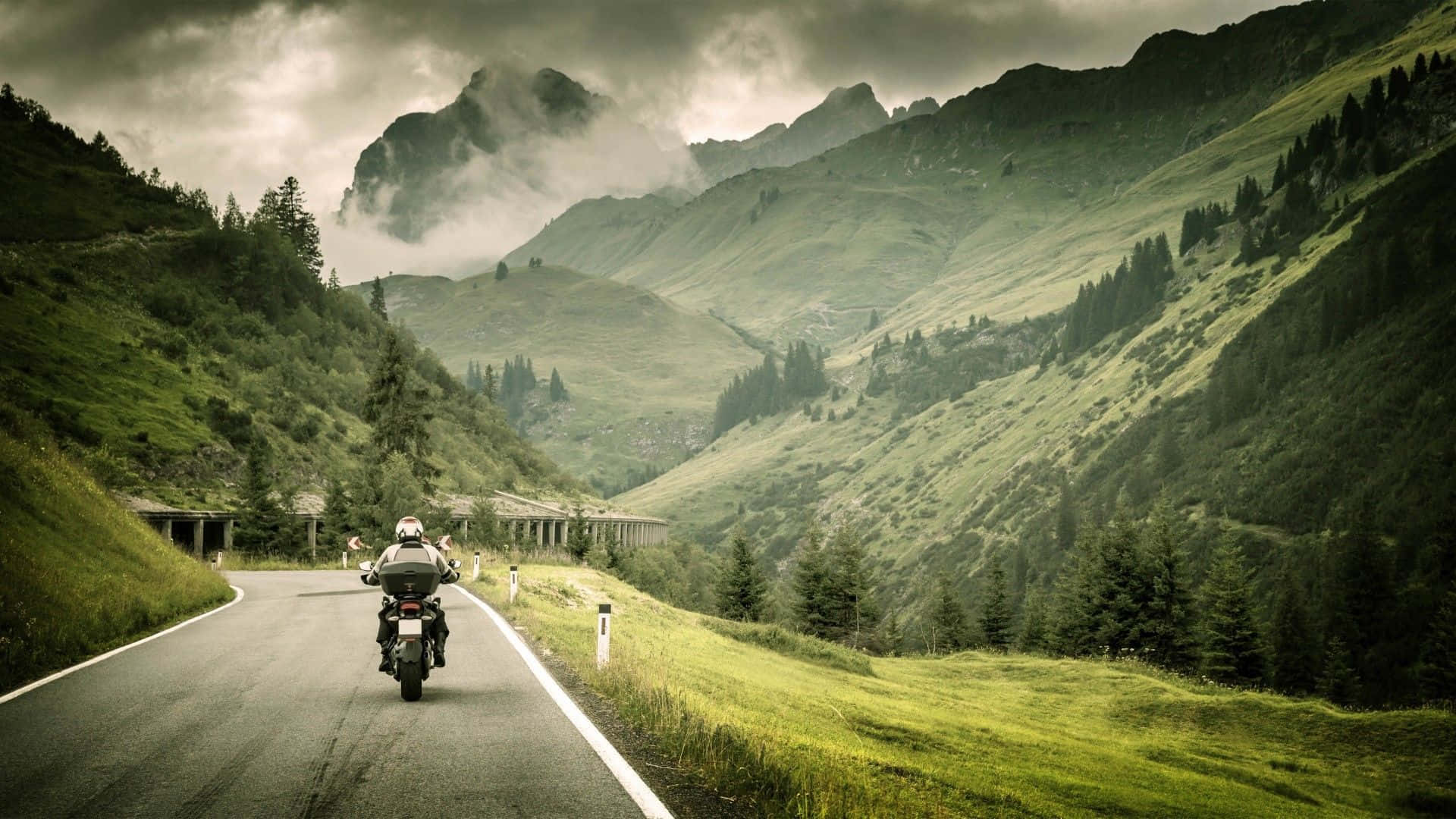 Hintergrundbildmit Motorrad, Das Die Straße Entlang Fährt.
