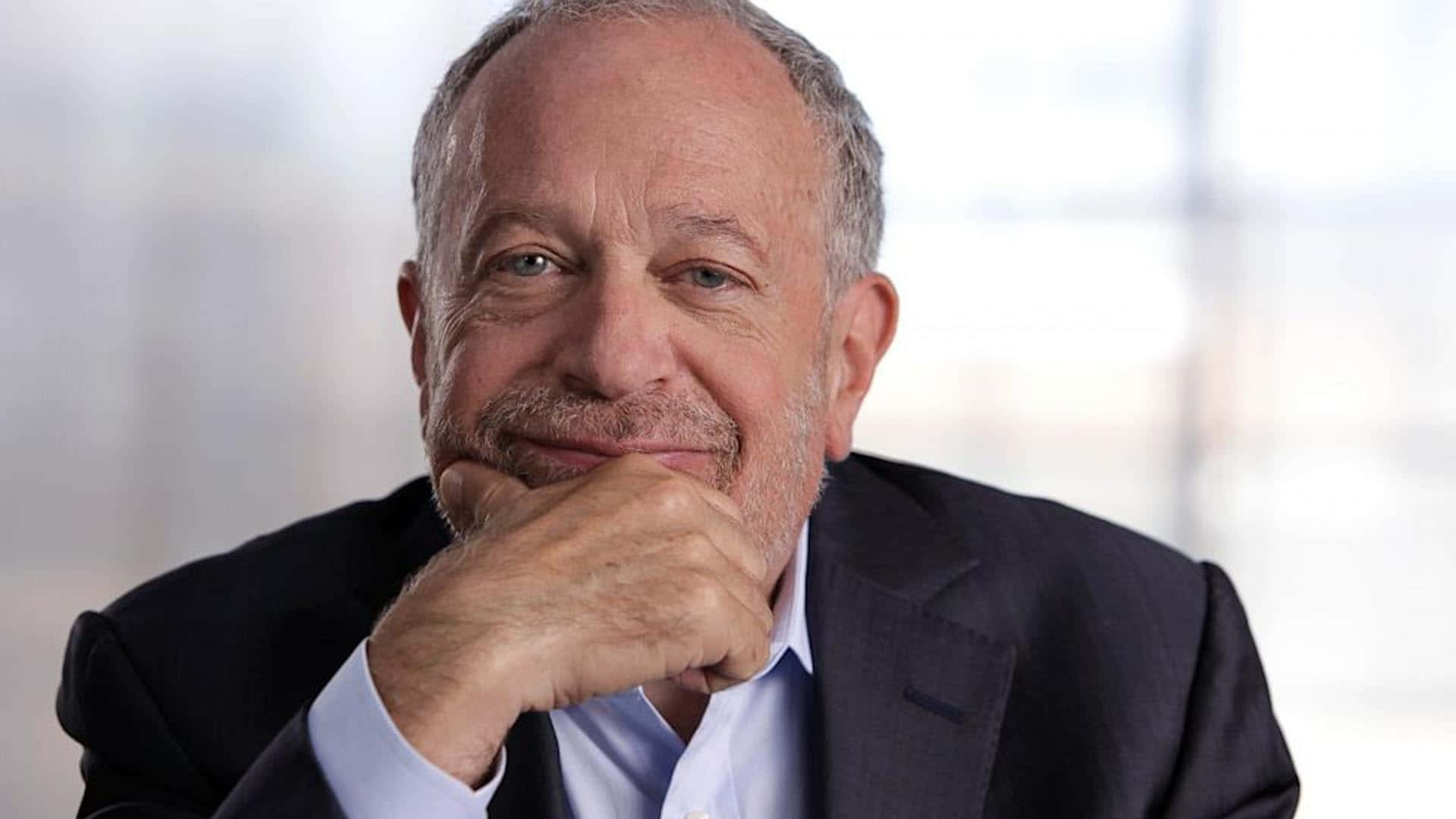 Robert Reich In A Formal Setting, Making A Point During A Discussion Wallpaper