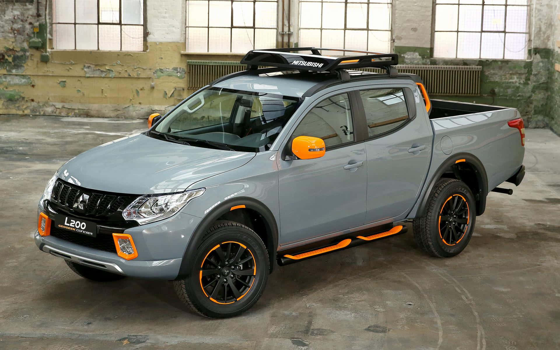 Robust Mitsubishi Triton Gliding Through A Scenic Off-road Landscape Wallpaper