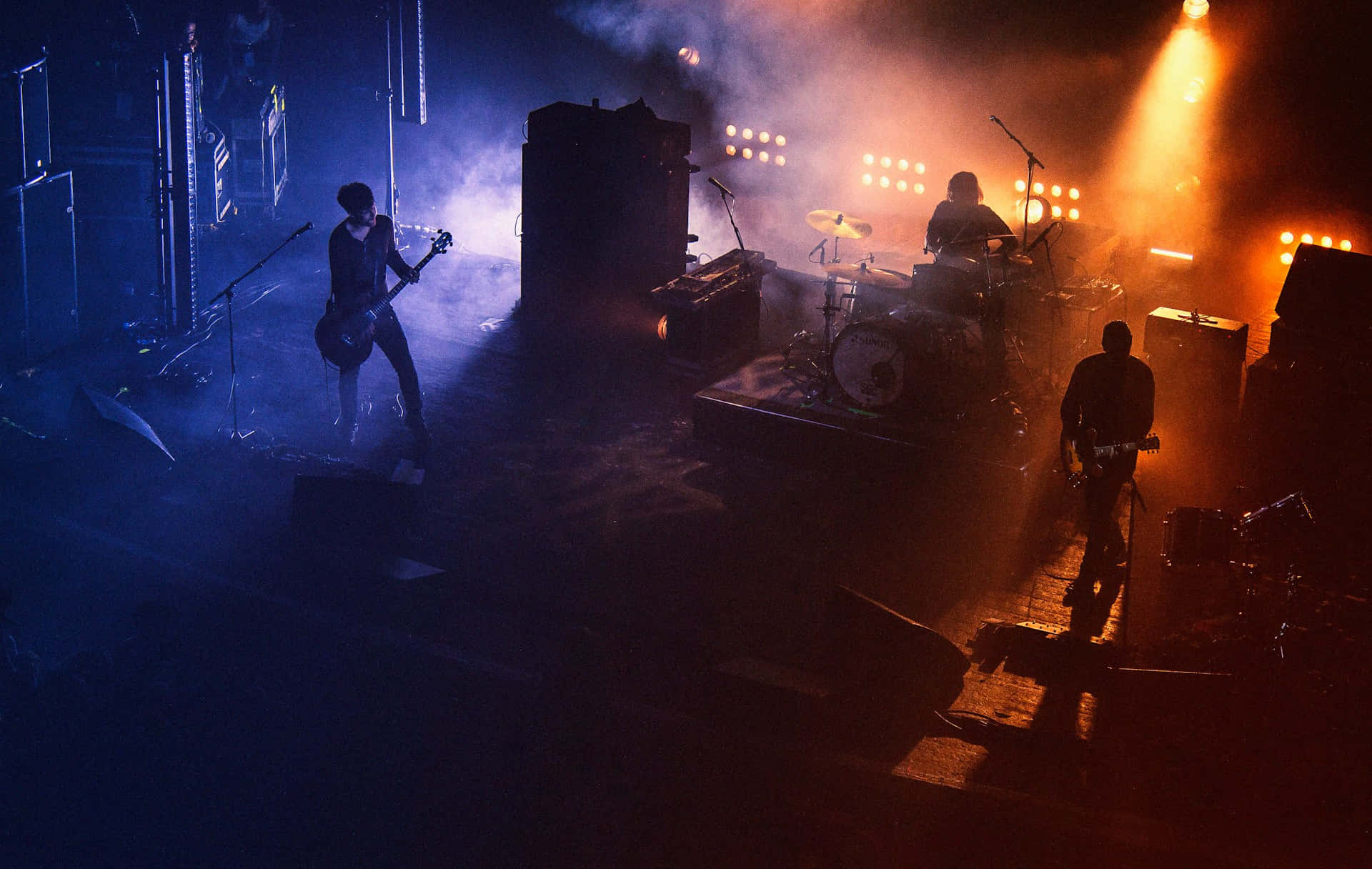 Rock Band Performingon Stagein Smoky Atmosphere Wallpaper