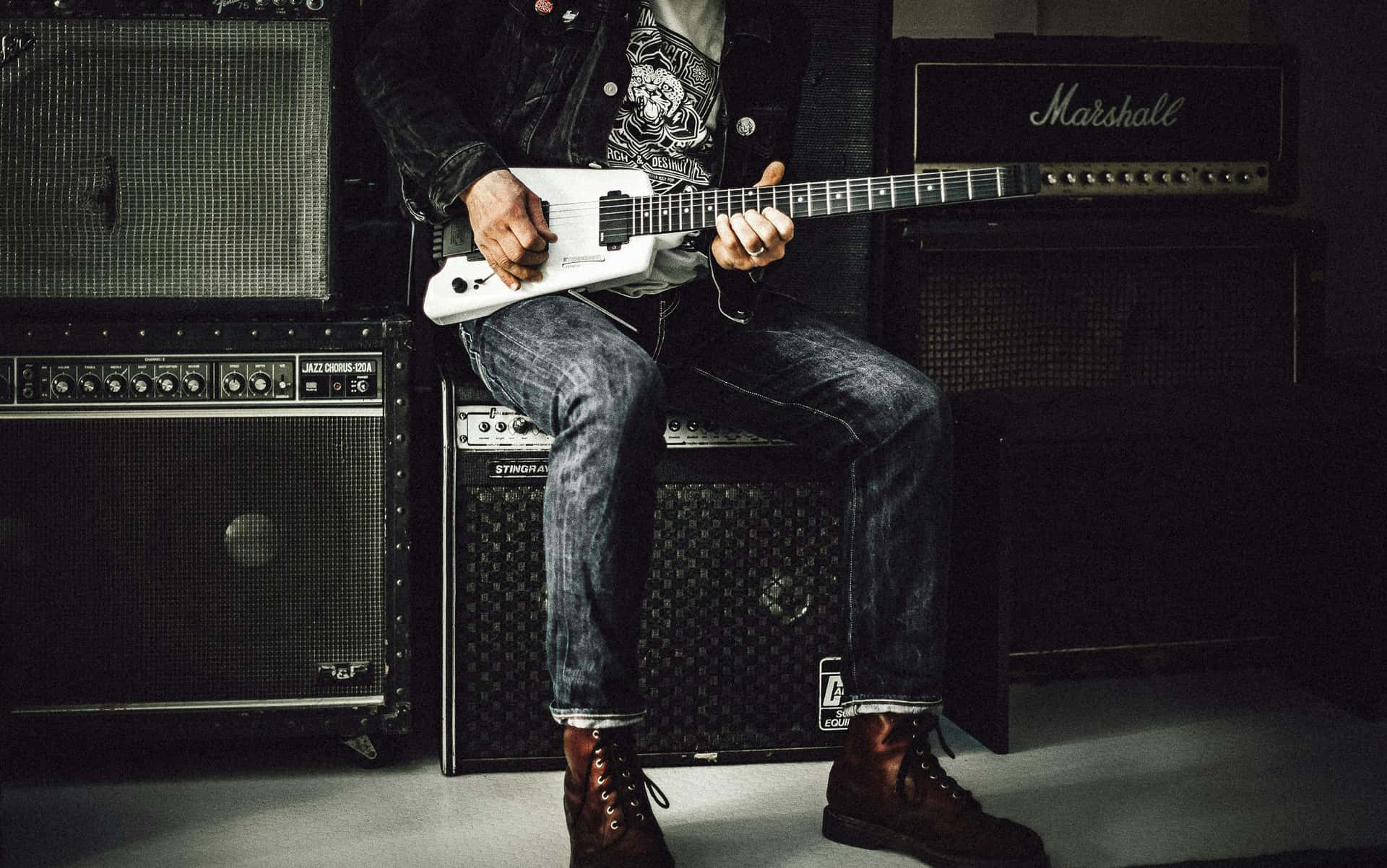 Rock Guitarist Amidst Amplifiers Wallpaper