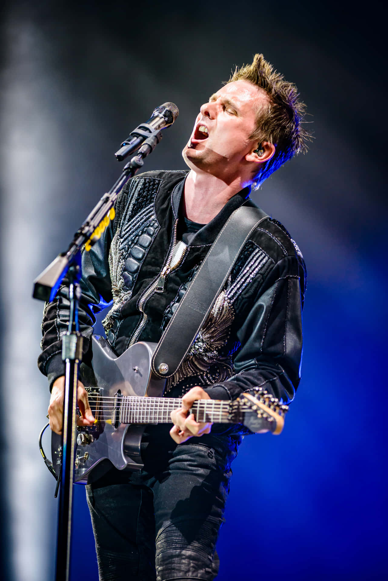 Rock Guitarist Singing Passionately Live Concert Wallpaper