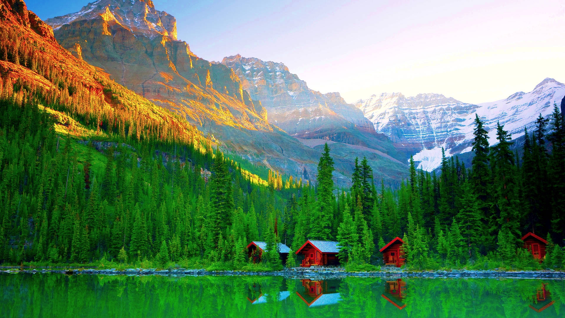Rocky Mountain Behind Log Cabins By The Lake Wallpaper
