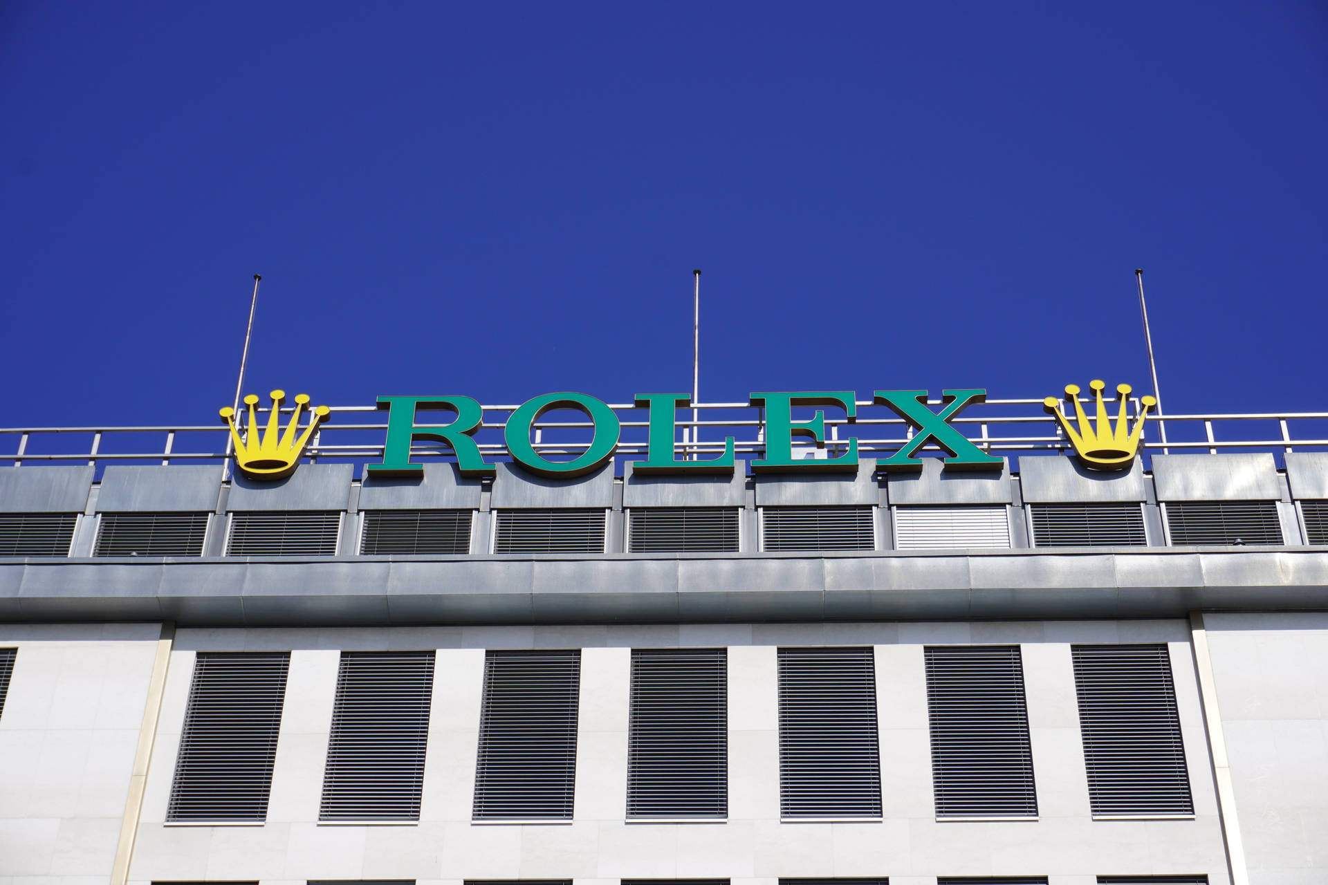Logoet til Rolex på bygningens væg Wallpaper