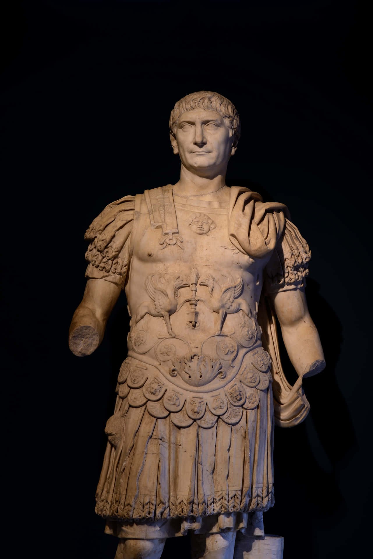 A Statue Of A Roman Man In A Dark Room