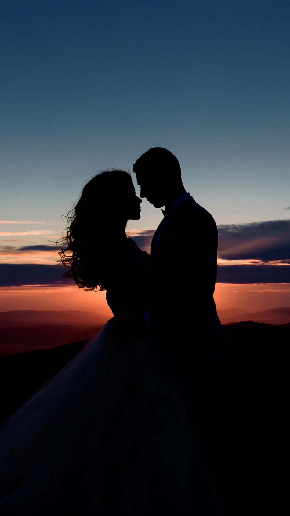 Silhouette af par med romantiske aftenhimlen baggrund