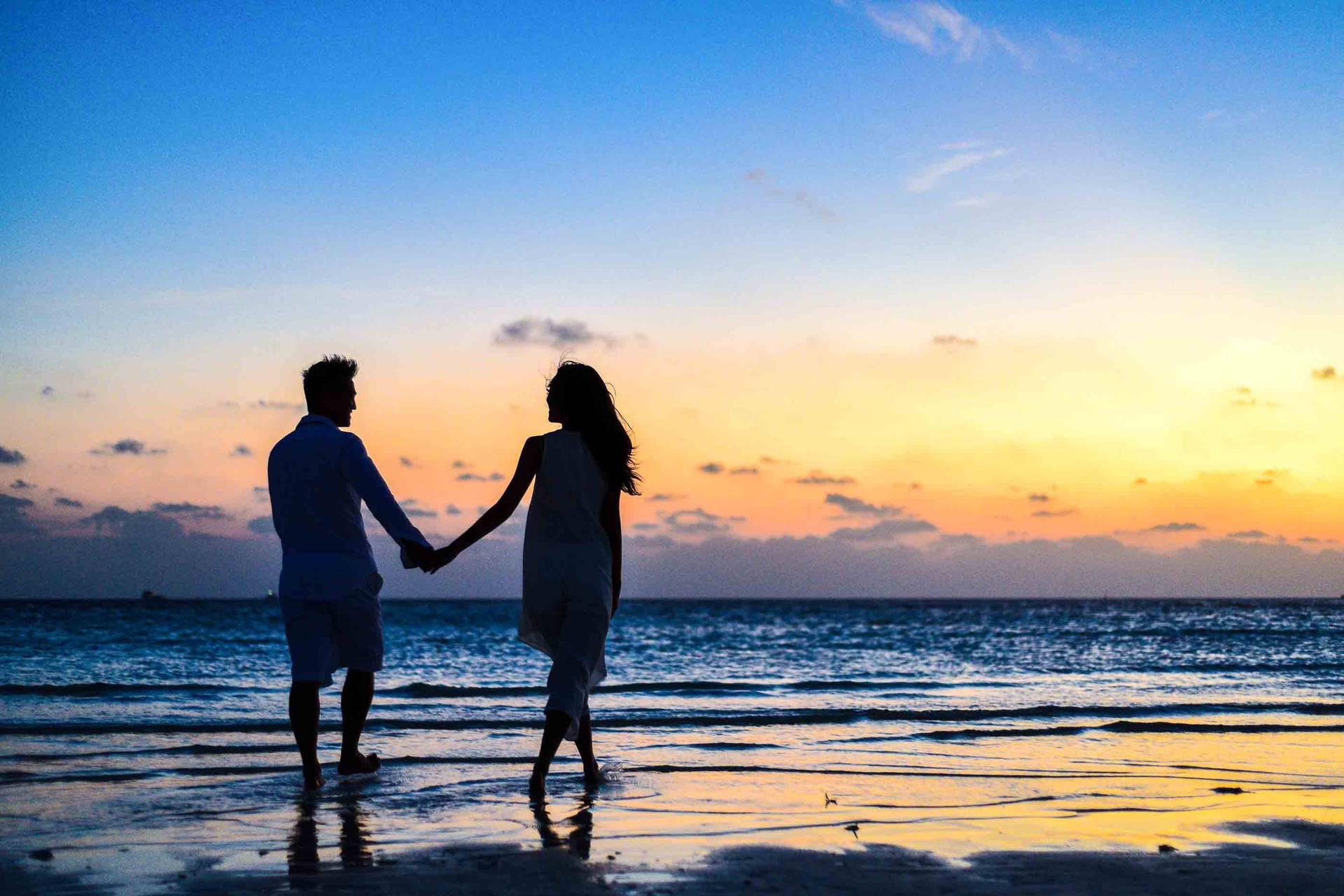 Romantic Couple Holding Hands On Seashore Wallpaper