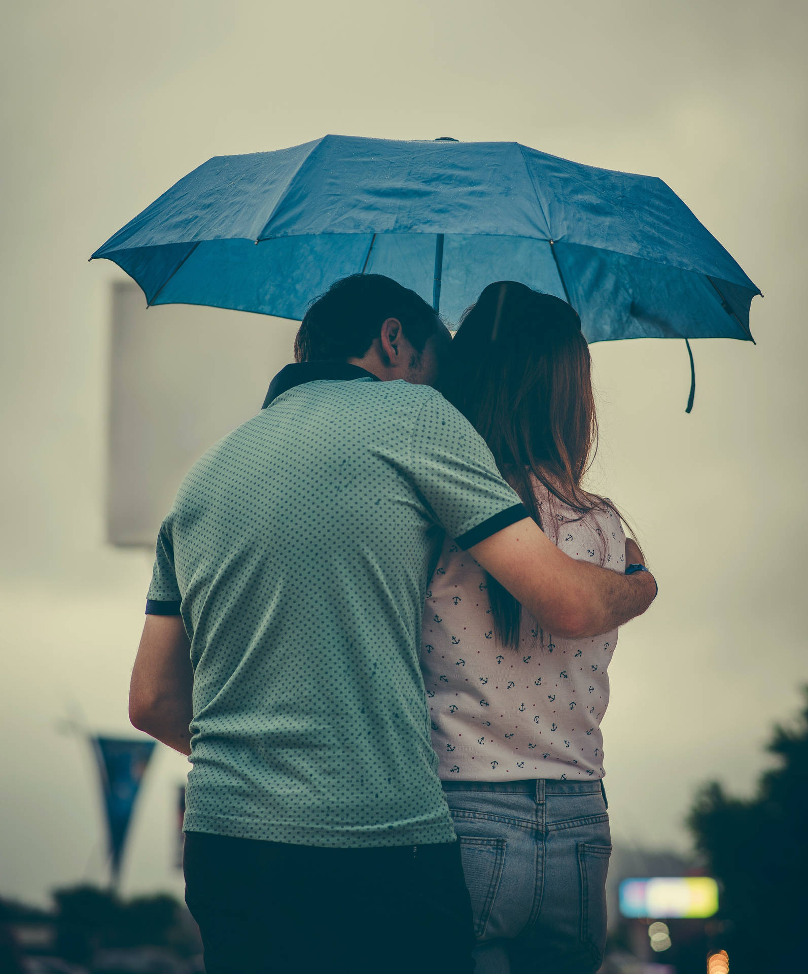 Romantisktpar Kysser Under Ett Paraply. Wallpaper
