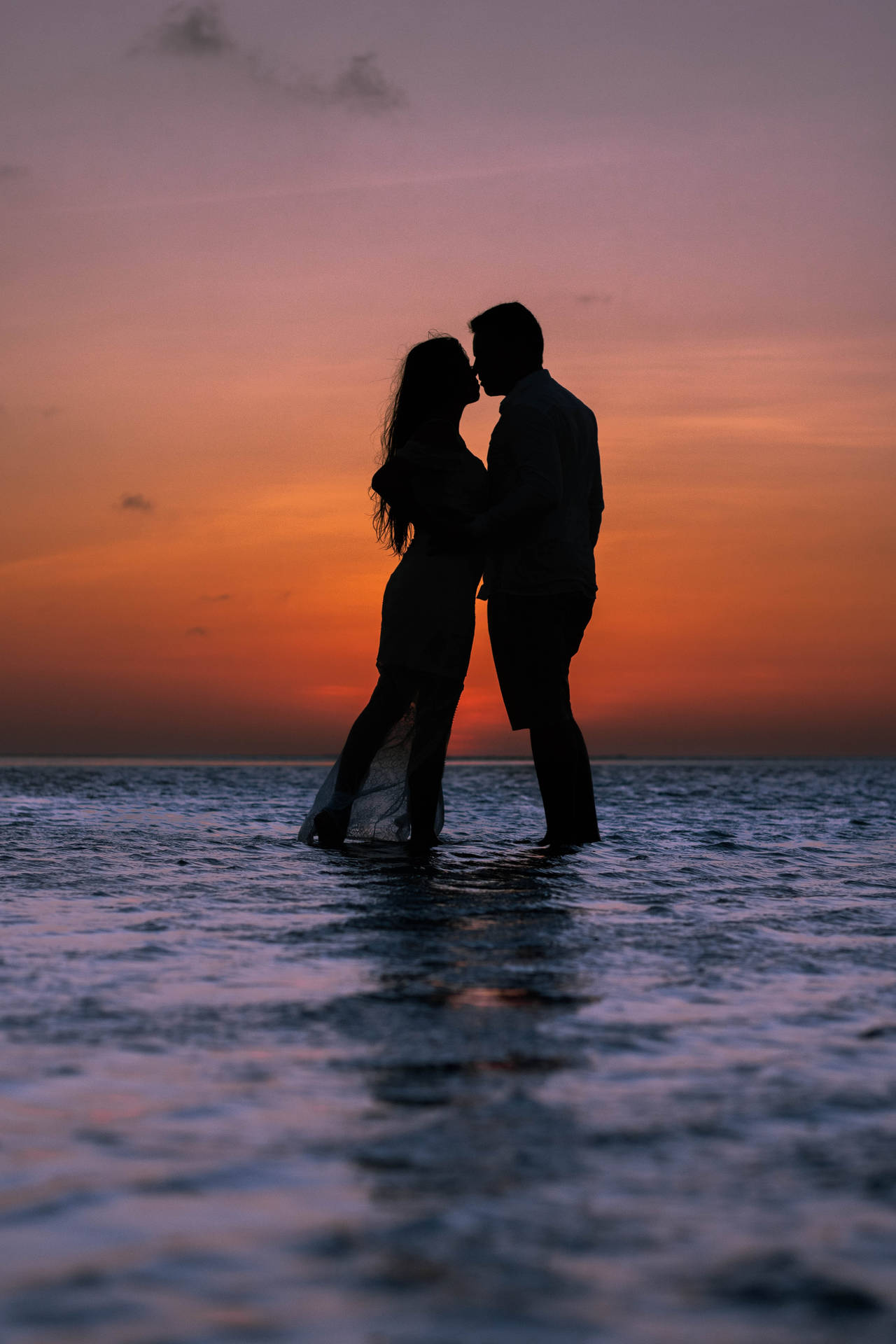 Romantischespaar Bei Sonnenuntergang Am Meer Küssen Wallpaper