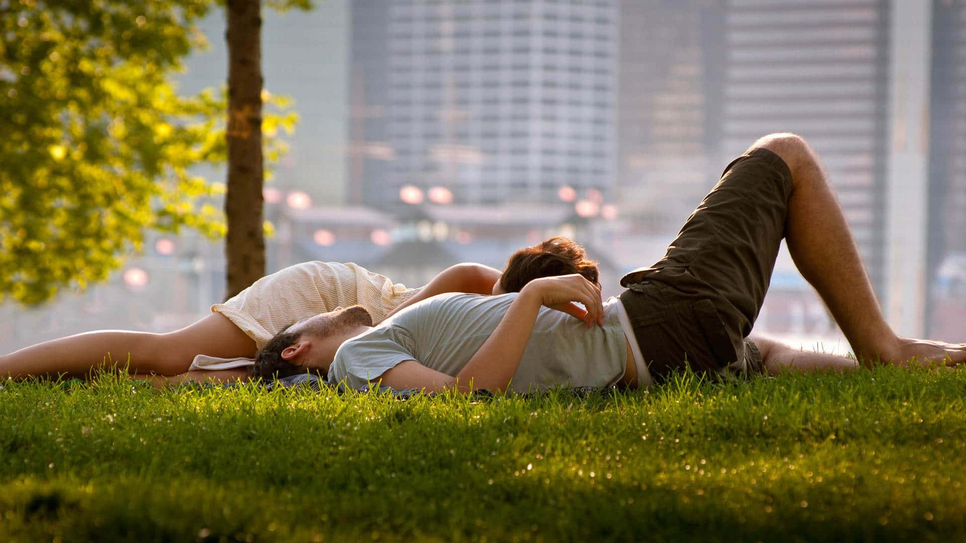 A Couple Laying On The Grass