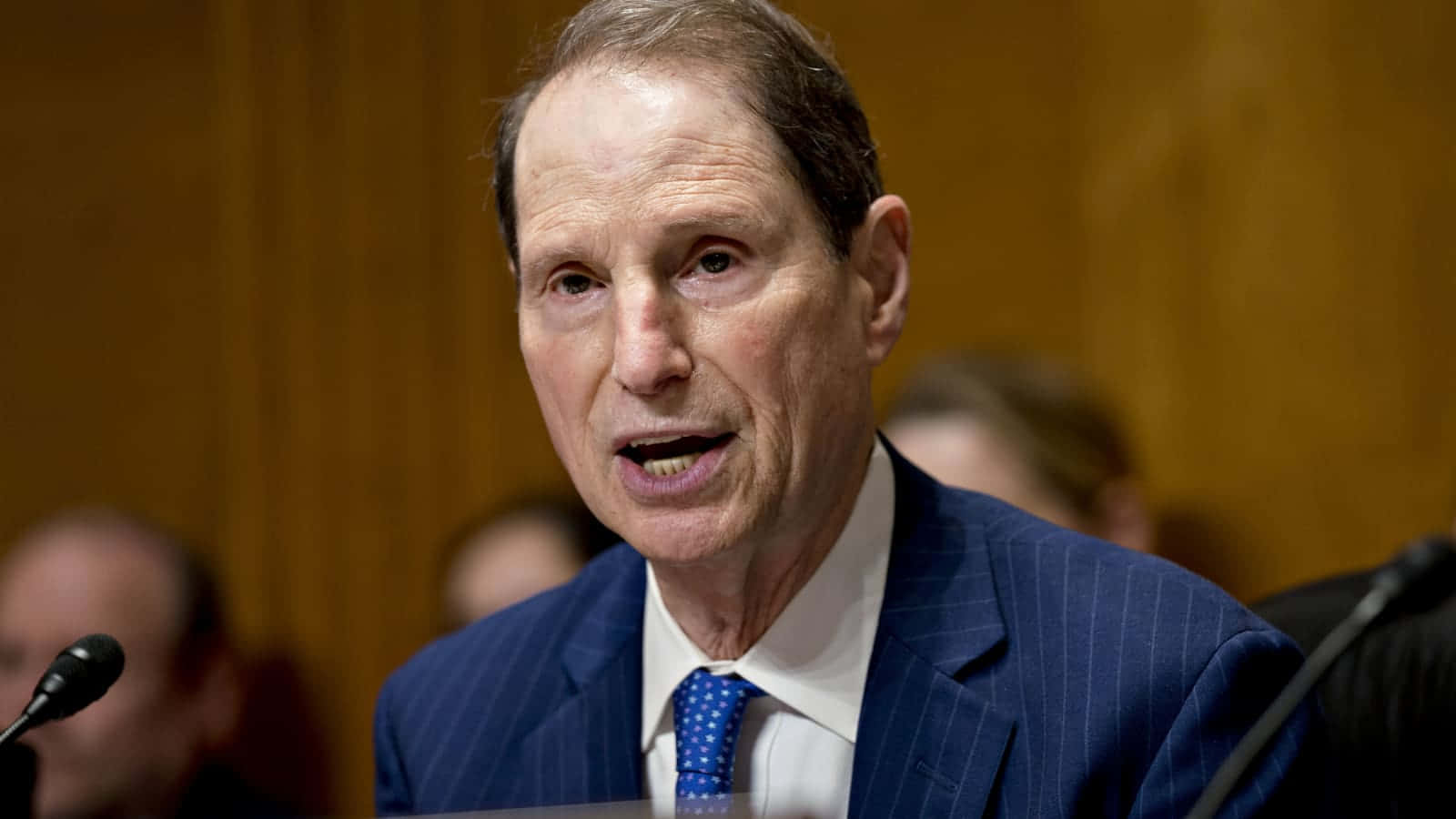U.S. Senator Ron Wyden looking thoughtful in a blue suit and tie. Wallpaper