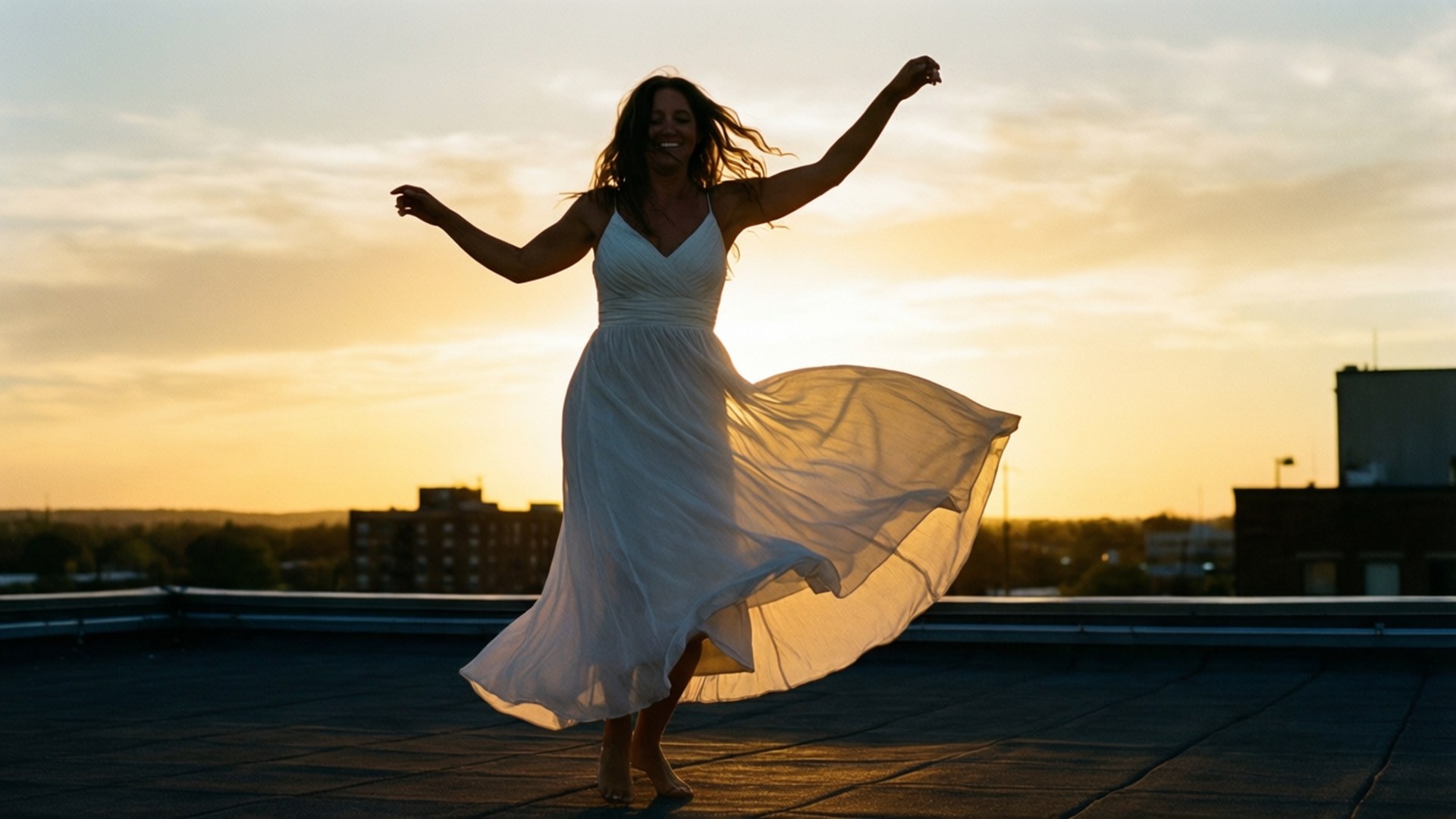 Katrina Bowden danser på et tak ved solnedgang, silhuett