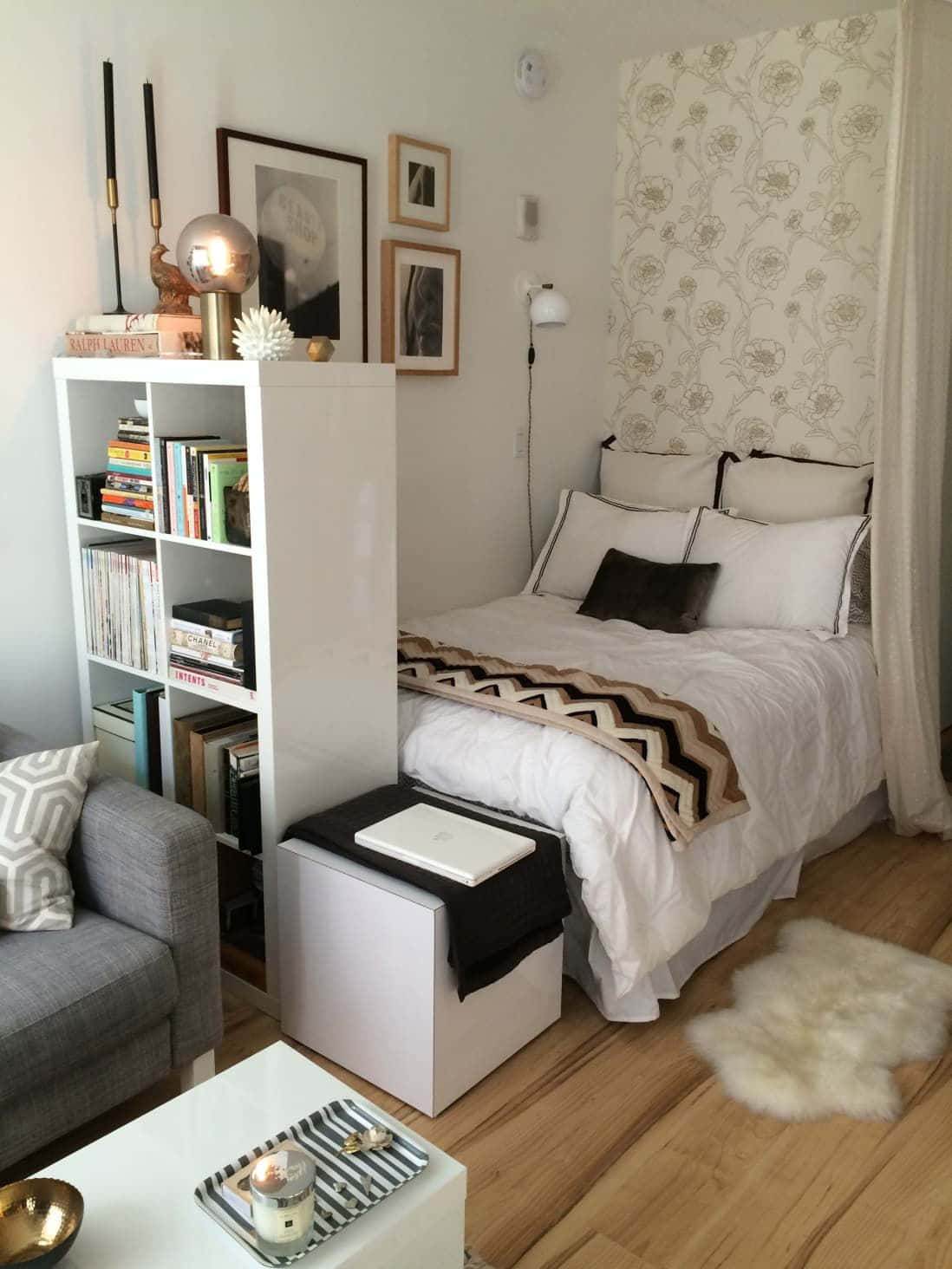 A Small Bedroom With A Bed, Couch And Bookshelf