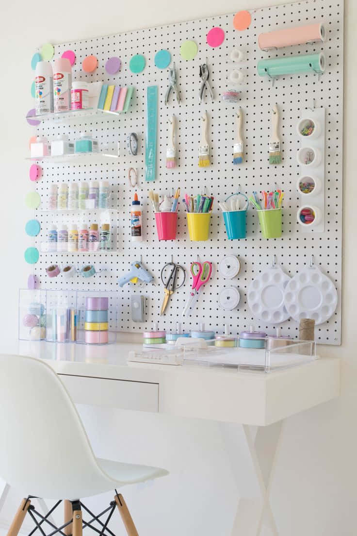 A White Desk With A Peg Board And A Chair