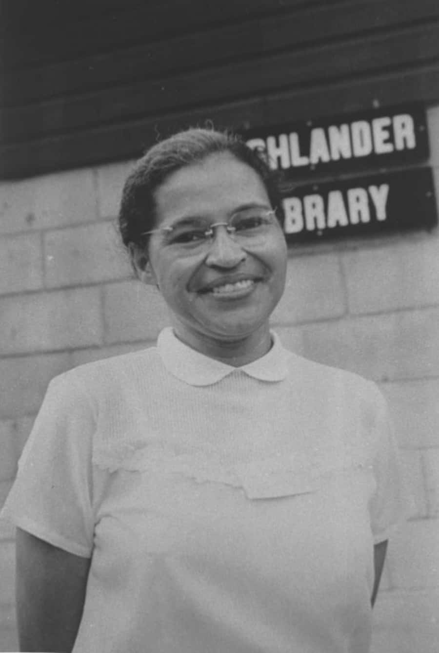 A Woman In A White Shirt Standing In Front Of A Library