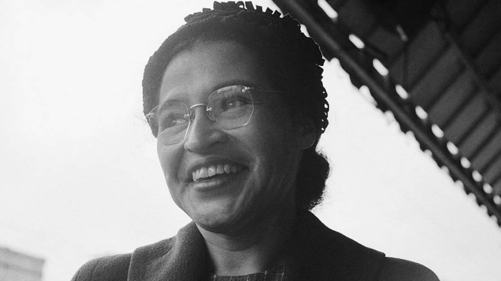 A Woman Wearing Glasses And A Jacket Smiling