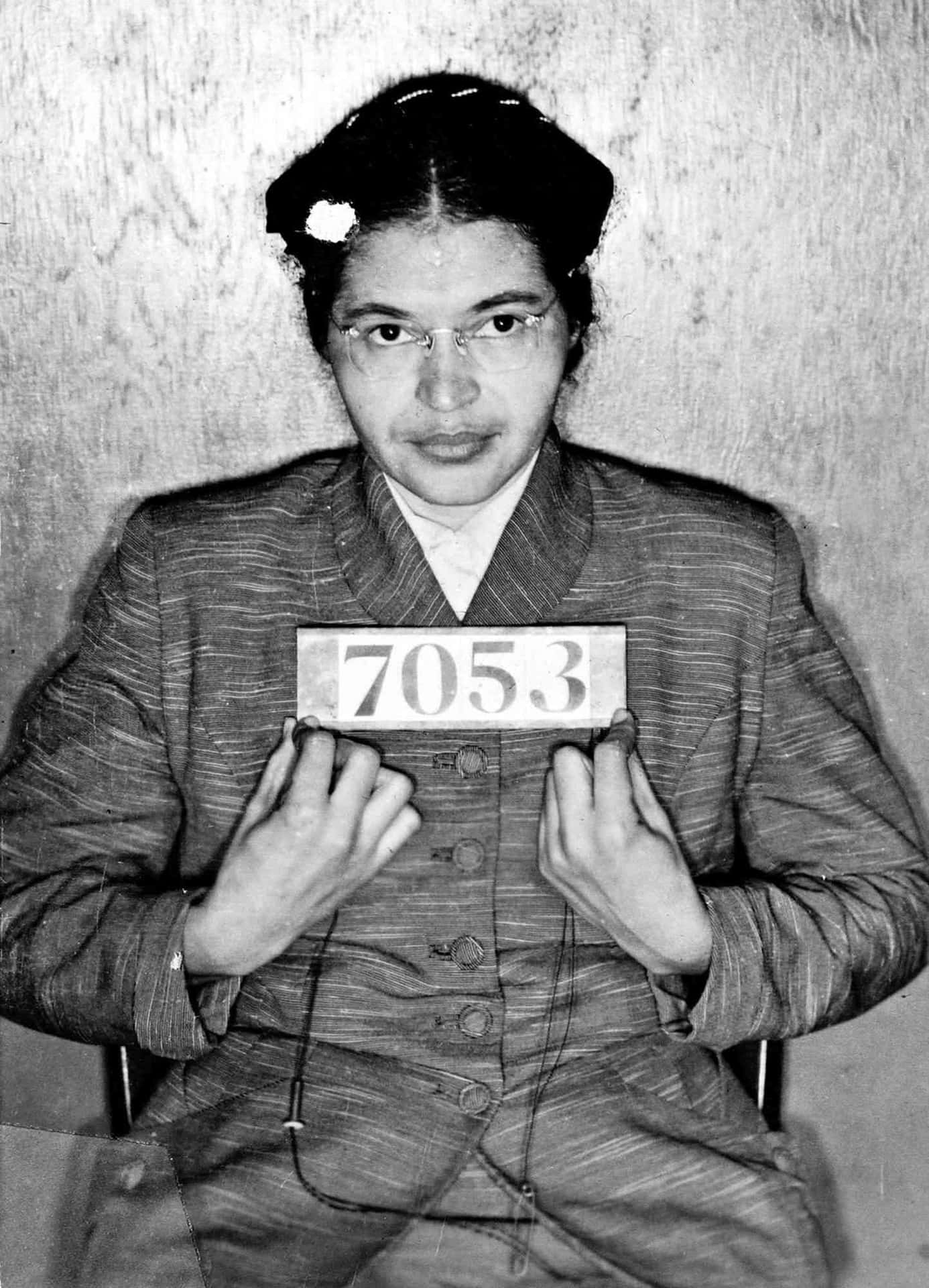 A Woman Holding Up A Sign With A Mugshot