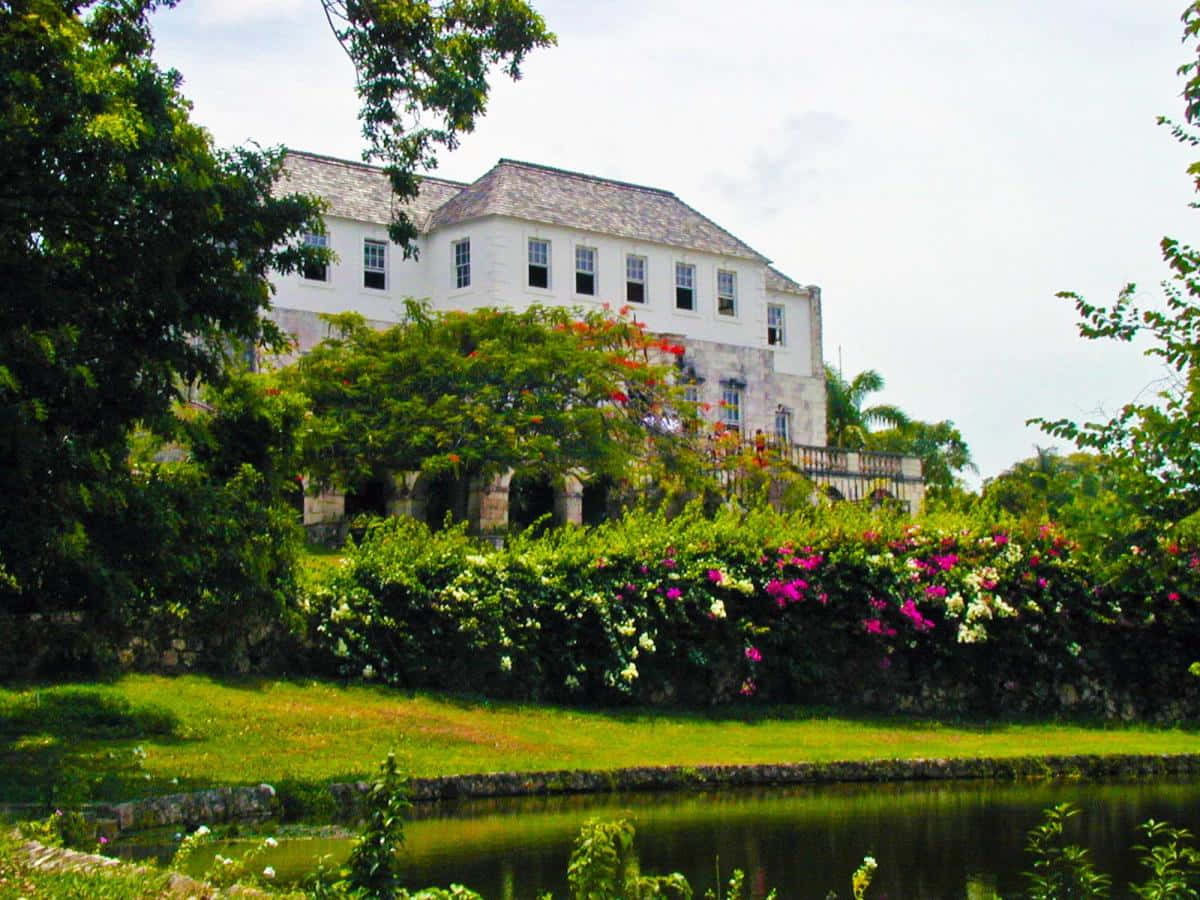 Breathtaking view of the historic Rose Hall Great House amidst lush greenery. Wallpaper