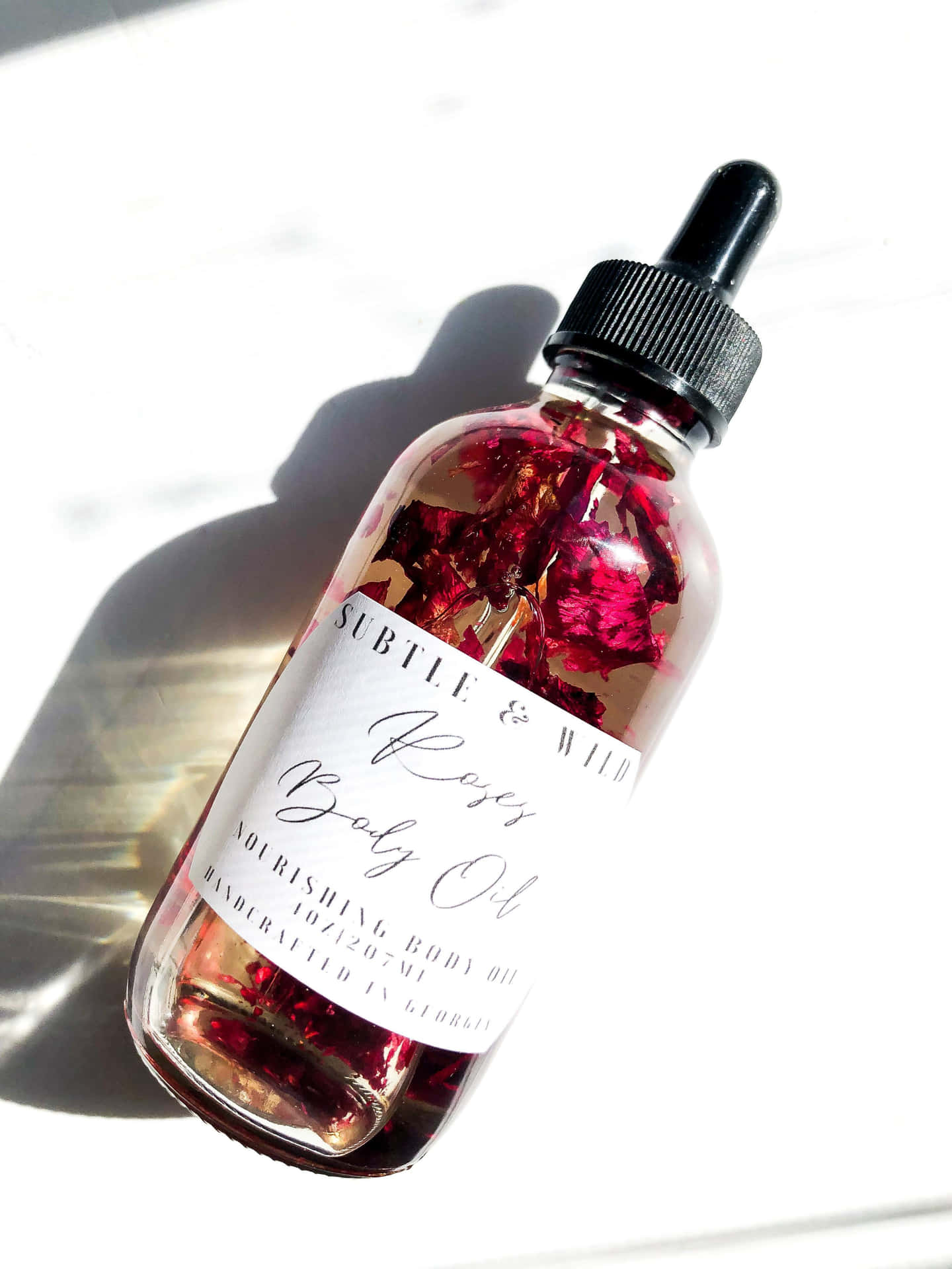 Luxurious Rose Oil in a Dropper Bottle Wallpaper