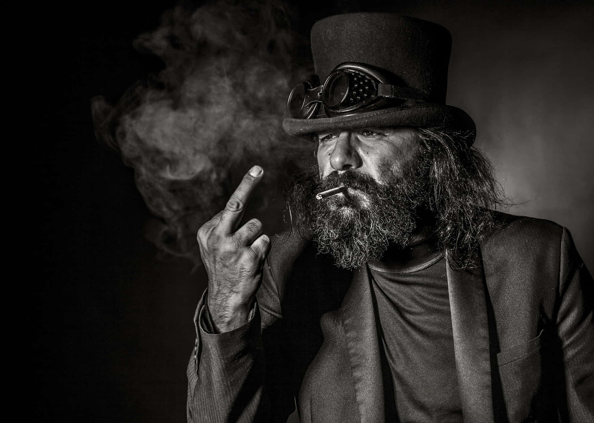 A Man With Long Hair And A Top Hat Smoking A Cigarette Wallpaper