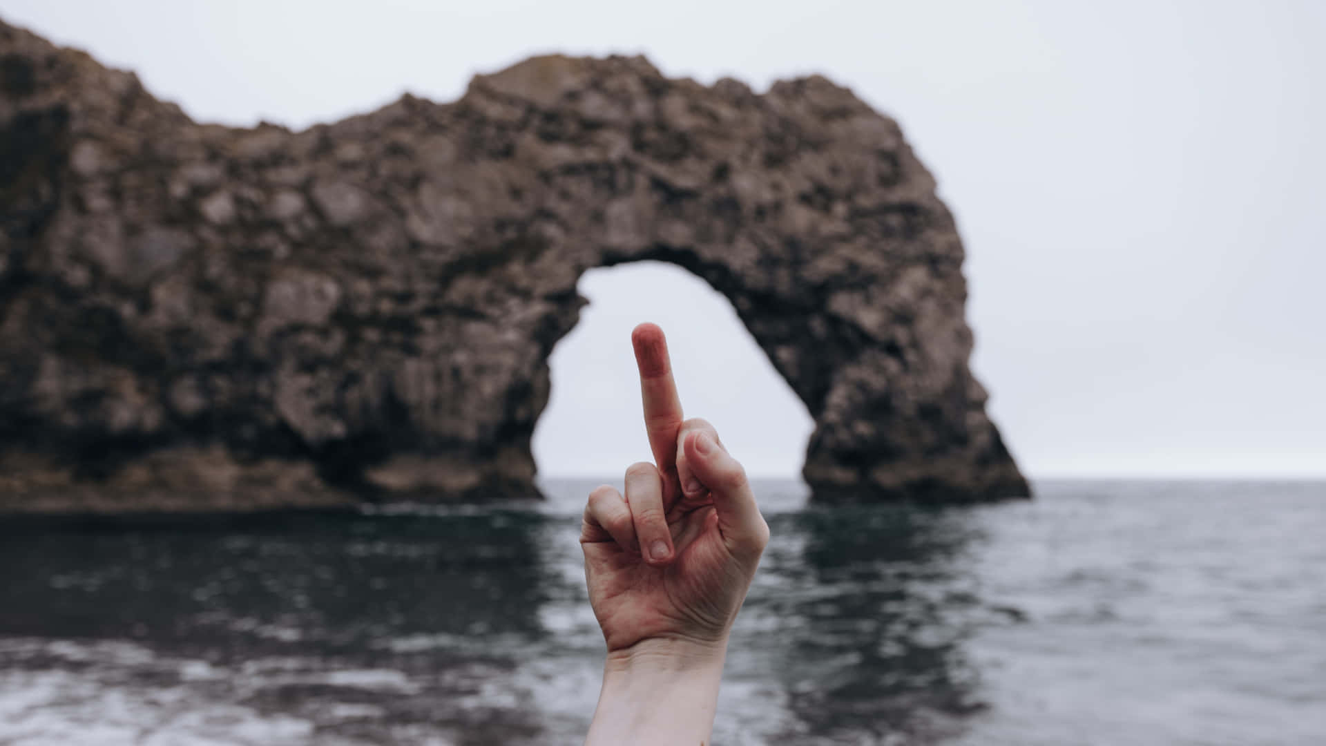 A Person's Finger Pointing At A Rock Formation Wallpaper