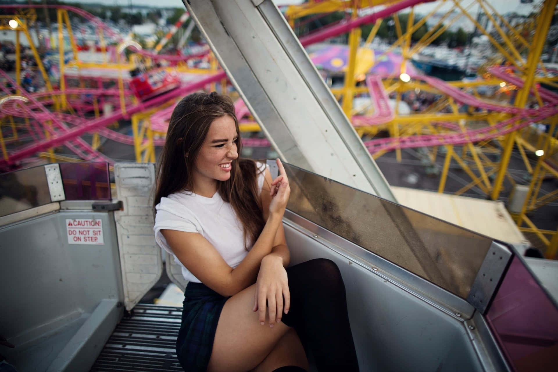 A Young Woman Sitting On A Ferris Wheel Wallpaper