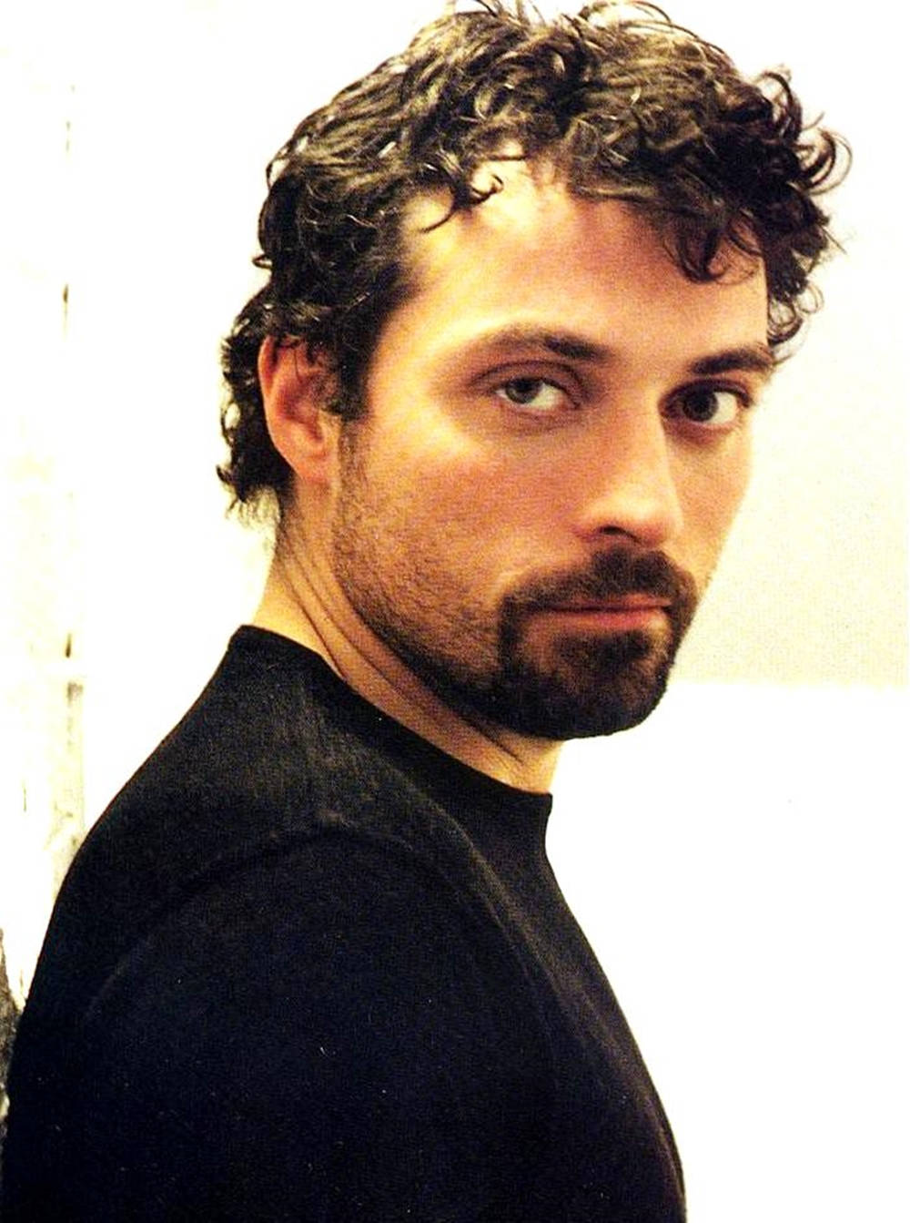 British Actor Rufus Sewell Posing with Curly Hair and Dark Beard Wallpaper