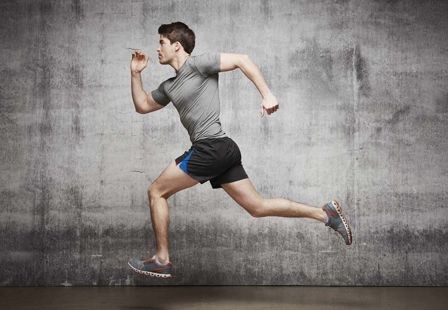 Download A Man Running In Front Of A Concrete Wall | Wallpapers.com