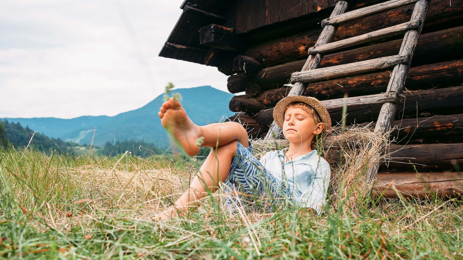 Rural Boy Resting Near Cabin Wallpaper