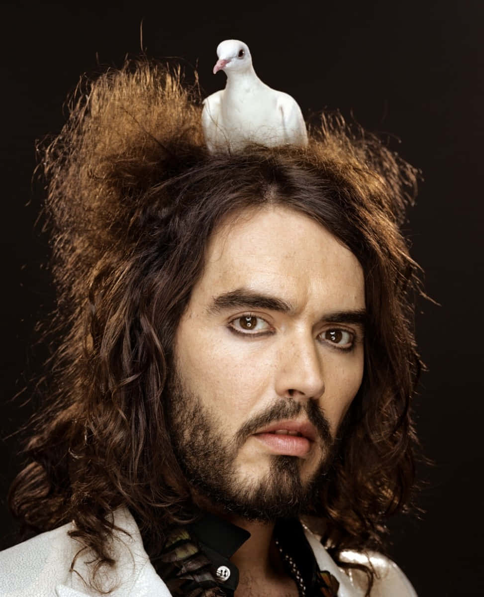 Comedian Russell Brand interacting with a bird Wallpaper