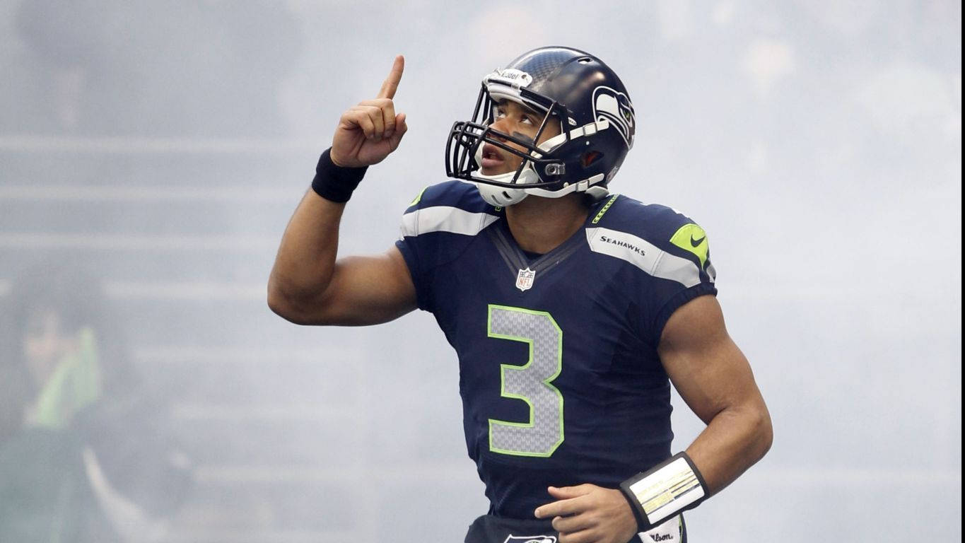 Russell Wilson Pointing Up Surrounded By Fog Wallpaper